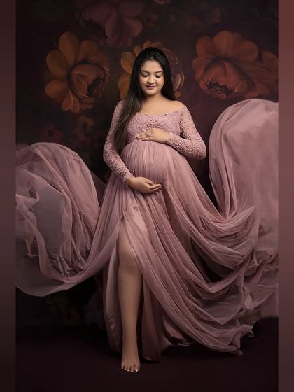 Lost in a dream. This full-length portrait captures the elegance of our dusty rose gown, with its delicate lace and flowing tulle creating a soft, romantic feel against a floral backdrop.