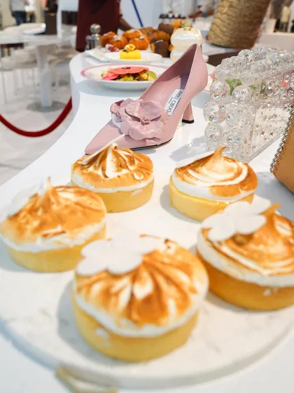 Lemon meringue tarts displayed alongside a Jimmy Choo shoe at the Ajio Luxe Café. This composition perfectly illustrates our "food meets fashion" concept.