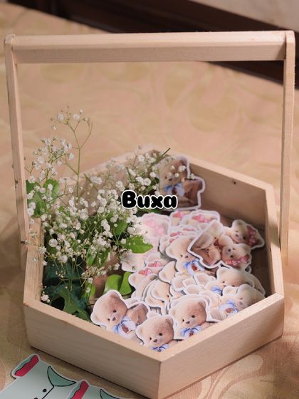 The beginnings of a teddy bear themed baby shower centerpiece, with custom cutouts and fresh baby's breath in a pinewood basket.