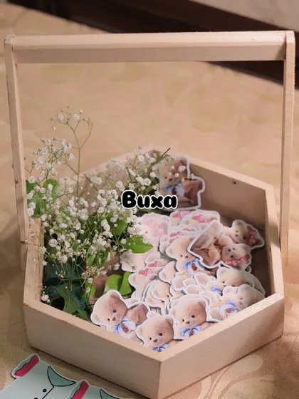 The beginnings of a teddy bear themed baby shower centerpiece, with custom cutouts and fresh baby's breath in a pinewood basket.