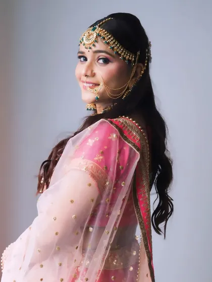 A side profile that shows the complete look, including the hairstyle, dupatta setting, and the soft glam makeup.