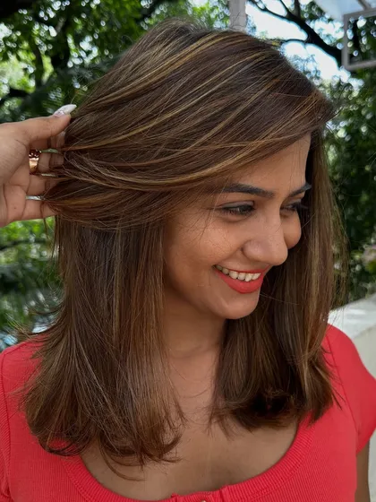 Be the life of every party with hair that shines. I gave her these bold, chunky highlights on a layered cut for a fun and glamorous look that’s sure to turn heads.