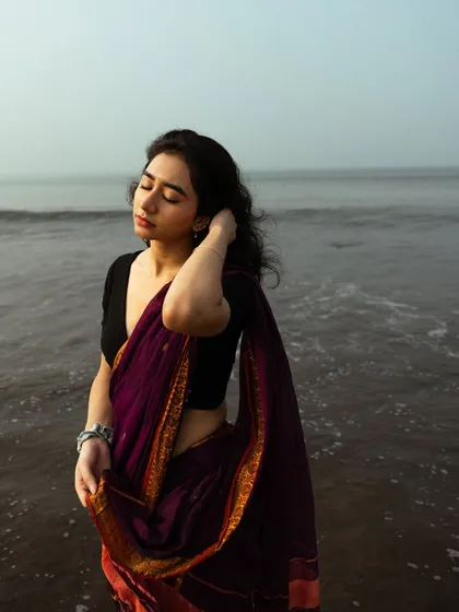 A serene moment with eyes closed, feeling the sea breeze. This shot is all about capturing a peaceful, sensory experience.