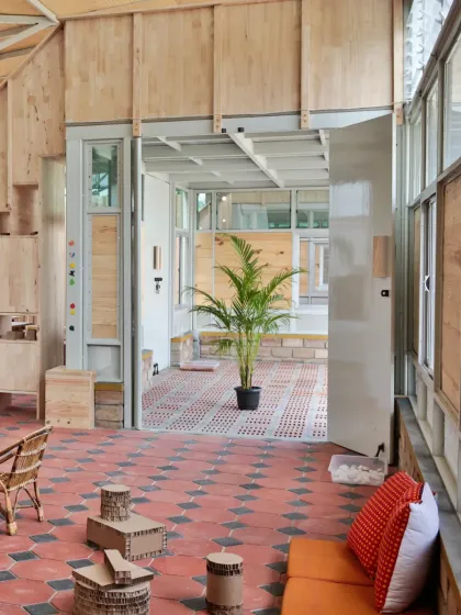 These images showcase the interior of the Atelier school, where partitions are made from recycled paper tubes. This innovative material choice is not only sustainable but also creates a playful, maze-like environment that encourages exploration and imaginative play.