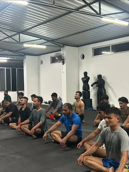 A moment of calm and focus. The team meditates together after a tough seminar. We train the mind just as much as the body.