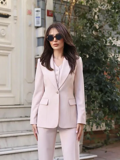 A full view of this beautiful three-piece suit in a soft, dusty pink. The set includes a single-breasted blazer, a matching waistcoat, and tailored straight-leg trousers.