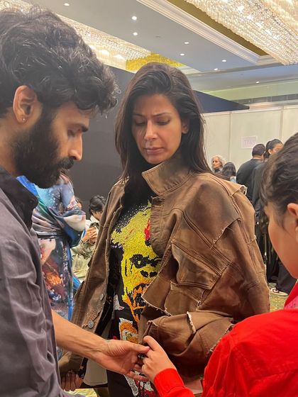 Another backstage moment, ensuring the fit and fall of a jacket is perfect just before the model walks the ramp for Huemn.