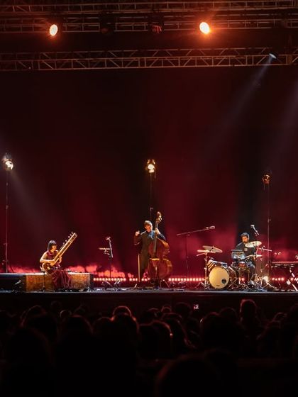 The full band on stage during Anoushka Shankar's tour, bathed in dramatic lighting. Our production team designs and executes sophisticated lighting and stage plots to enhance the musical performance.