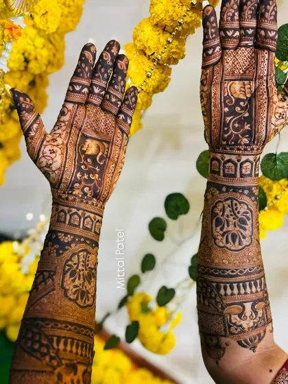 The front of the same bridal design, showing the full arm coverage and the rich detail of the elephant and floral patterns.