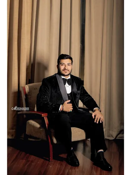 A classic seated portrait of the groom on his engagement day. The warm lighting and formal pose create a timeless and elegant image.