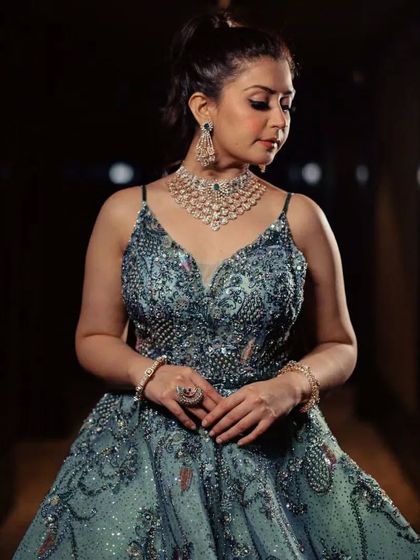 A close-up of the bodice of the grey-green gown, showing the intricate beading and the client's elegant diamond necklace.