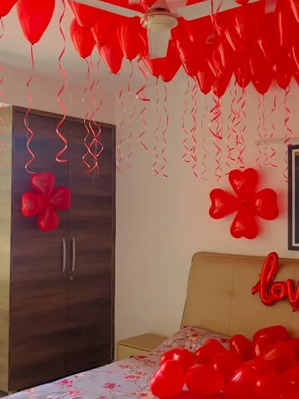 This view highlights the red heart-shaped balloons on the ceiling and the clover-shaped balloon arrangements on the walls.