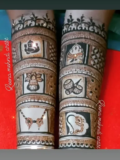 The upper arm portion of the storytelling bridal mehndi. This section includes auspicious symbols like Lord Ganesha, a kalash, dhol, and a mangalsutra, each representing a part of the wedding ceremony.
