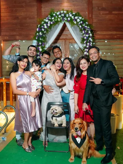 A fun group photo with family, friends, and even the dogs dressed for the occasion. This captures the full celebration and the important people (and pets) who are there to support the couple.