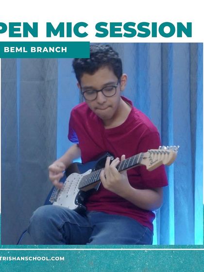 A student playing a black and white electric guitar at the BEML open mic session.