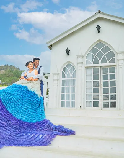 A stunning ruffled, multi-toned gown from our collection cascades down the steps of our white villa, making for an unforgettable pre-wedding picture.