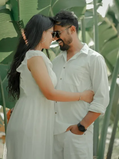 An intimate moment with foreheads touching, framed by the vibrant green leaves of a Pune garden. This shot feels private and serene, perfectly capturing the couple's deep connection.