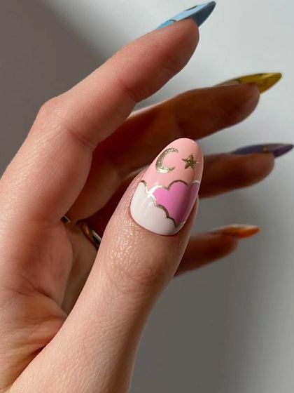 A close-up of the thumb nail from the celestial set, showing a pink heart-shaped cloud with a gold moon and stars.
