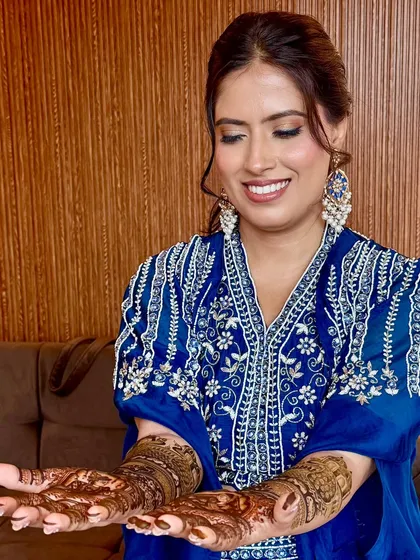 The bride showing off her beautiful Mehendi. The makeup is designed to complement the traditional aspects of the ceremony.