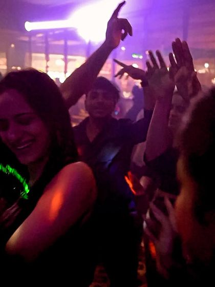 Lost in the music. A photo of the crowd with their hands in the air, dancing under the club lights.