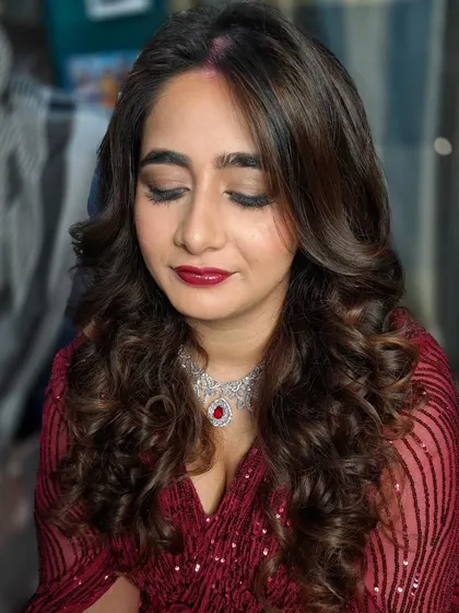 A close-up of this gorgeous reception glam. The look features a soft brown smokey eye, a deep berry-red lip, and beautiful, bouncy curls that frame the face perfectly.