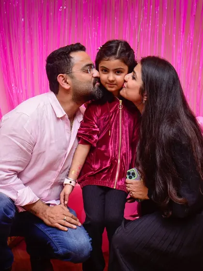 Priceless bonds. A sweet family photo with kisses for the birthday girl.