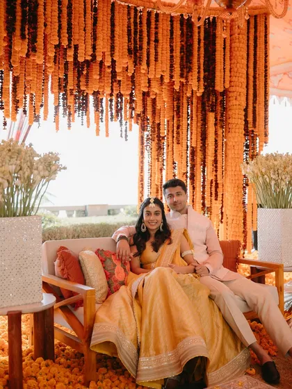 A couple surrounded by a sea of vibrant marigolds. We love using traditional elements in modern, impactful ways to create spaces that are not only beautiful but also rich in cultural meaning and joy.