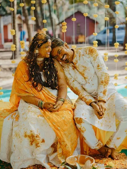 A sweet moment after the main event, with the couple covered in haldi, resting together. It shows the happy exhaustion and love that fills the day.