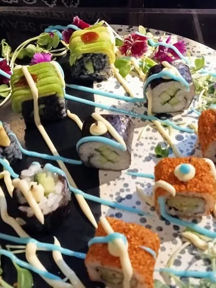 A platter of our specialty sushi rolls, featuring colorful toppings and creative drizzles. We use high-quality ingredients to create rolls that are as delicious as they are beautiful, perfect for a sophisticated gathering.