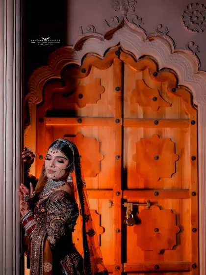 A profile shot of the bride against a carved wooden door, highlighting her serene expression and traditional jewelry.