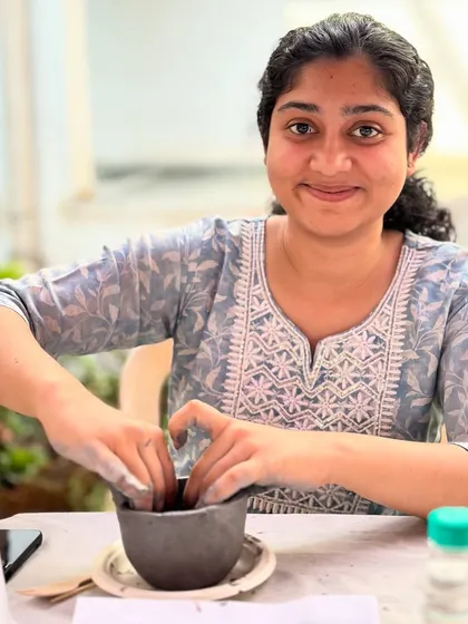 A research scholar from ACTREC smiling as she gets her hands dirty. These workshops prove that creativity is a wonderful outlet for even the most analytical minds.
