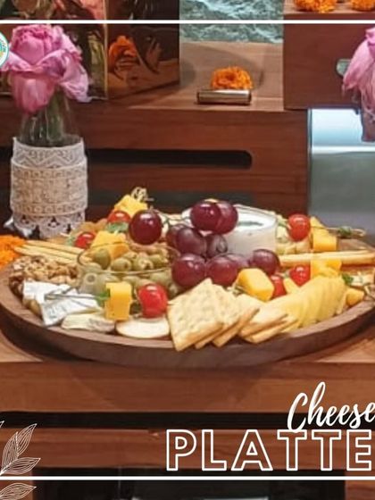 A beautiful Cheese Platter set up on a wooden grazing table, decorated with marigold flowers for a festive touch. This is a perfect addition to any house party or holiday get-together.