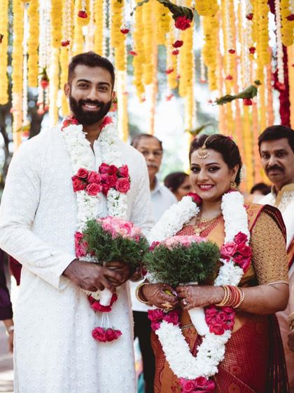 A happy couple posing after their wedding ceremony. Their smiles and the beautiful floral decor create a perfect picture of joy.