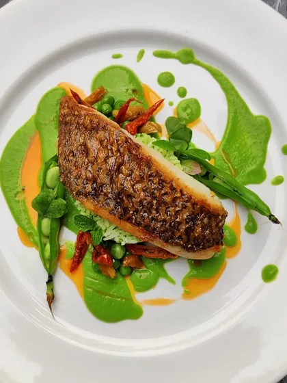 This is where our culinary skill shines. A perfectly pan-seared fish with crispy skin, served on a bed of herb rice with a vibrant coriander purée and a hint of chili oil. This dish represents our commitment to flavour, quality, and the art of plating.