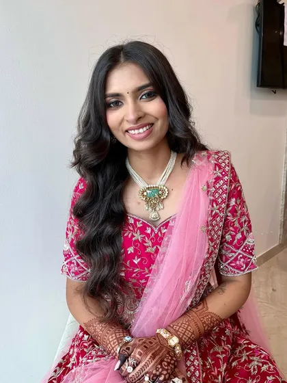 A pretty and fresh look for a pre-wedding event. The pink lehenga is complemented by a soft smokey eye and a natural pink lip.