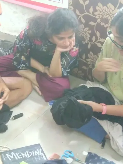 Our textile mending sessions are relaxed and collaborative. Here, participants are gathered on the floor, sharing tips and learning hand-sewing techniques together. It’s a perfect example of our grassroots, community-first approach to repair.