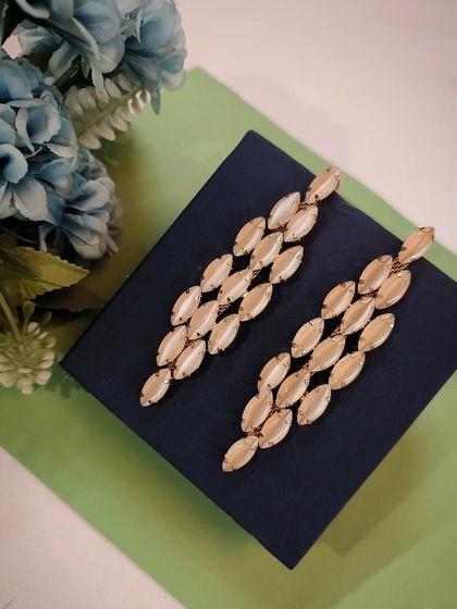 A product shot of the classy and delightful statement enamelled earrings, laid out to show their unique marquise shape.