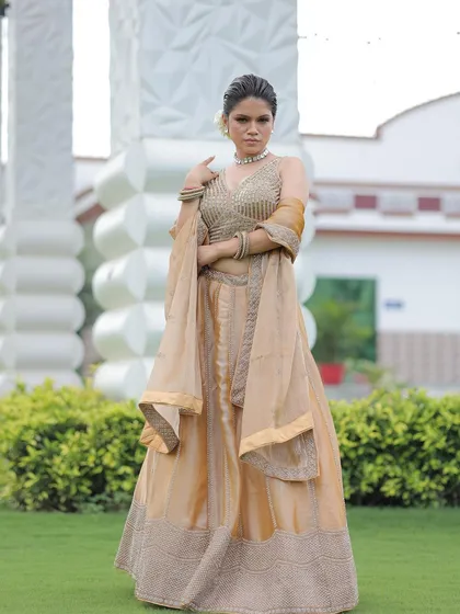 A full-length shot of the elegant gold lehenga, showcasing its shimmering fabric and minimalist design.