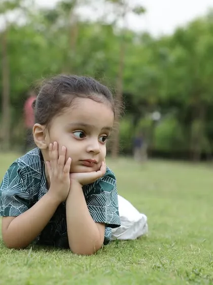 A thoughtful, candid portrait of a young child resting on the lawn. I always look for these unposed moments that reveal a child's natural personality and expressions.
