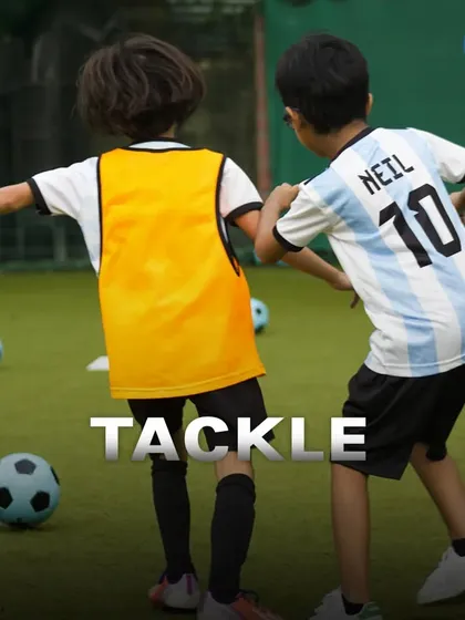 A young player executes a perfect tackle during a drill. I teach the fundamentals of both offense and defense to ensure players are prepared for any situation.