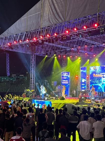 A side view of the 'Alive India' stage, showing the crowd's engagement and the impressive lighting truss structure.