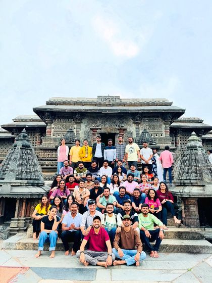 A large group from a corporate outing enjoying the architectural beauty of a Hoysala temple. I can build itineraries that balance adventure with cultural sightseeing for your team.
