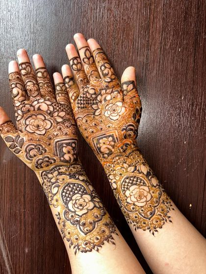 A classic Pakistani mehendi design with fine lines, delicate floral motifs, and checkered patterns. This style is known for its elegance and intricacy, covering the hands and wrists beautifully.