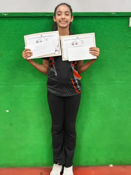 Hrithika Madhur smiles with her certificates after clinching the top spot in U-19 Girls and third in the Women's category at the 1st District Ranking Tournament.