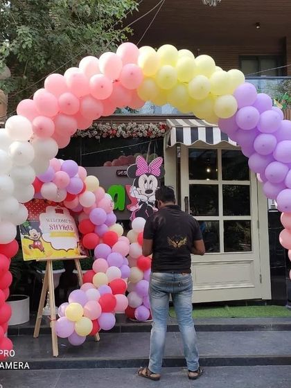 A wide view of the Minnie Mouse party entrance, showing a full pastel balloon arch that creates a festive welcome for guests.