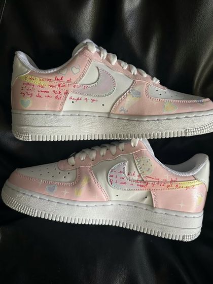A pair shot showing the handwritten lyrics detail on the "Lover" custom sneakers.