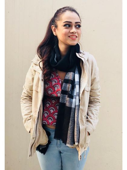 Layering is key for transitional weather. Here, I've added a light jacket and a scarf over a printed top and jeans. This not only adds warmth but also texture and dimension to the outfit.