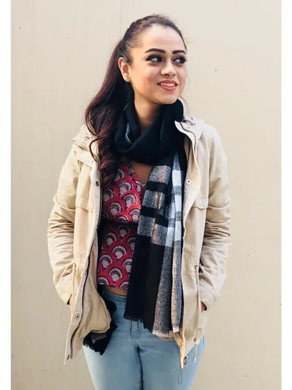 Layering is key for transitional weather. Here, I've added a light jacket and a scarf over a printed top and jeans. This not only adds warmth but also texture and dimension to the outfit.