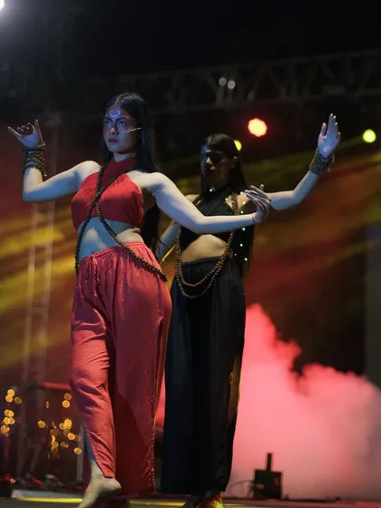 Two performers in a synchronized dance move. The composition and smoky background highlight their coordination and the mood of the performance.