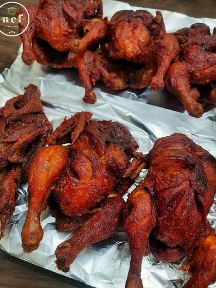 Whole fried chickens, fresh out of the pan and ready to be packed for an order. They are crispy, golden, and delicious.